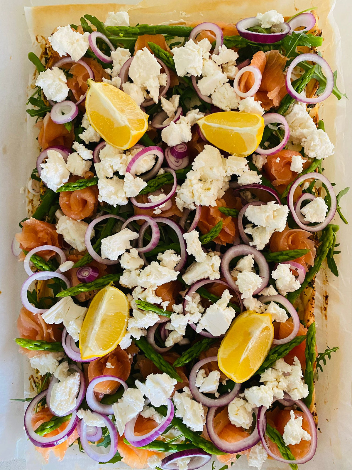 Tarte sur plaque au saumon, feta et fromage frais aux herbes, tout juste sortie du four
