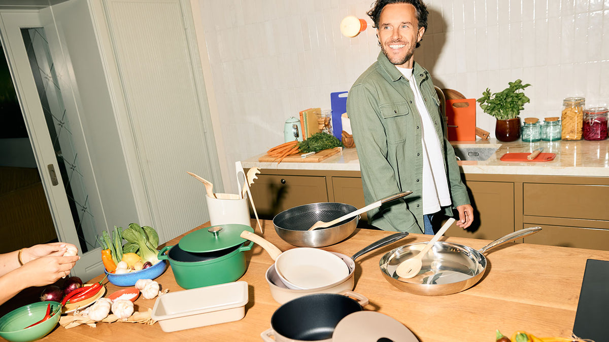 Man in de keuken bij een tafel vol Cook & Pan koekenpannen