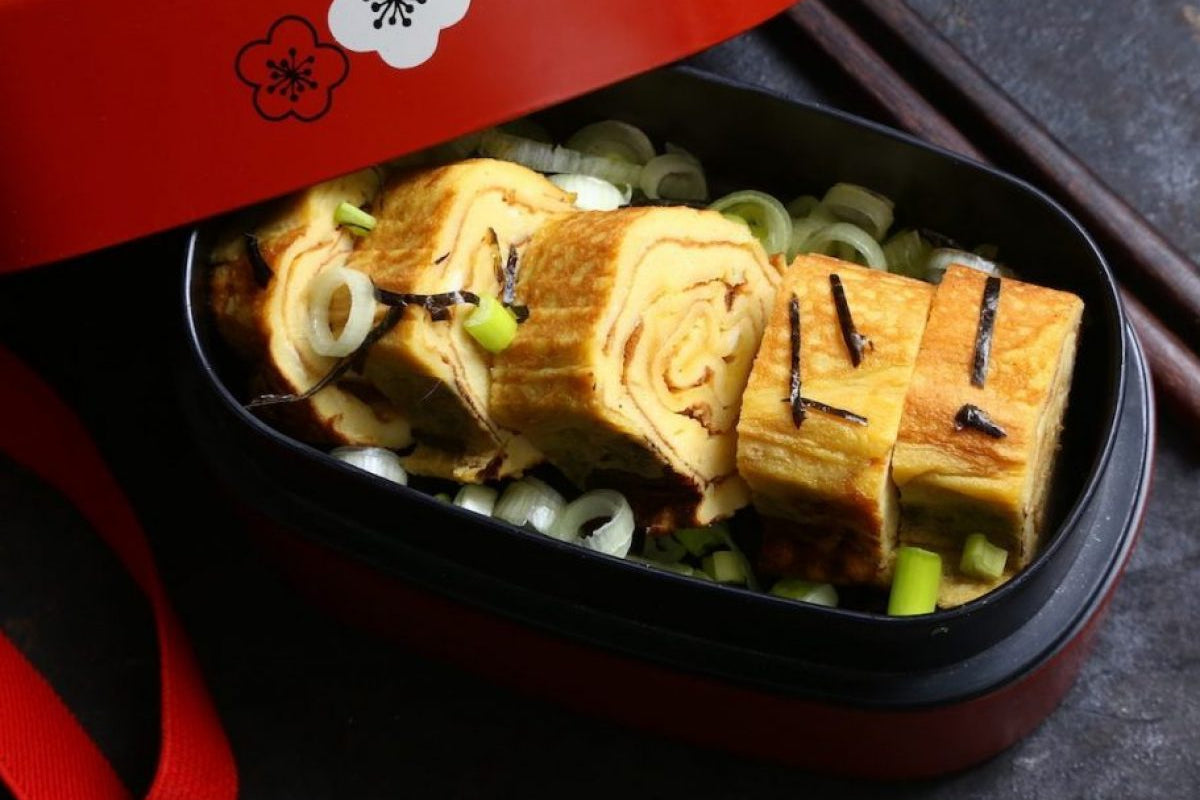 Opgerolde Japanse omelet tamagoyaki, stap voor stap gemaakt in de pan