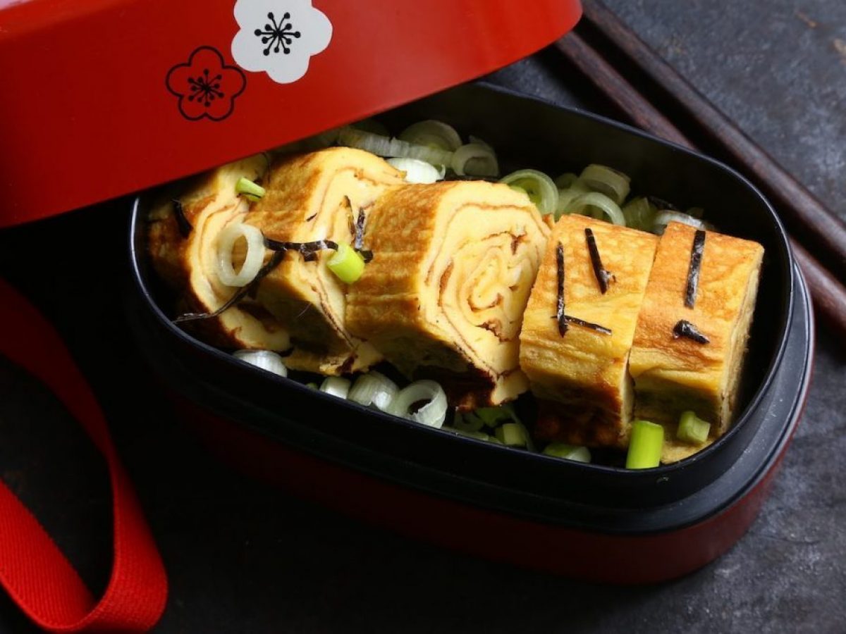 Opgerolde Japanse omelet tamagoyaki, stap voor stap gemaakt in de pan