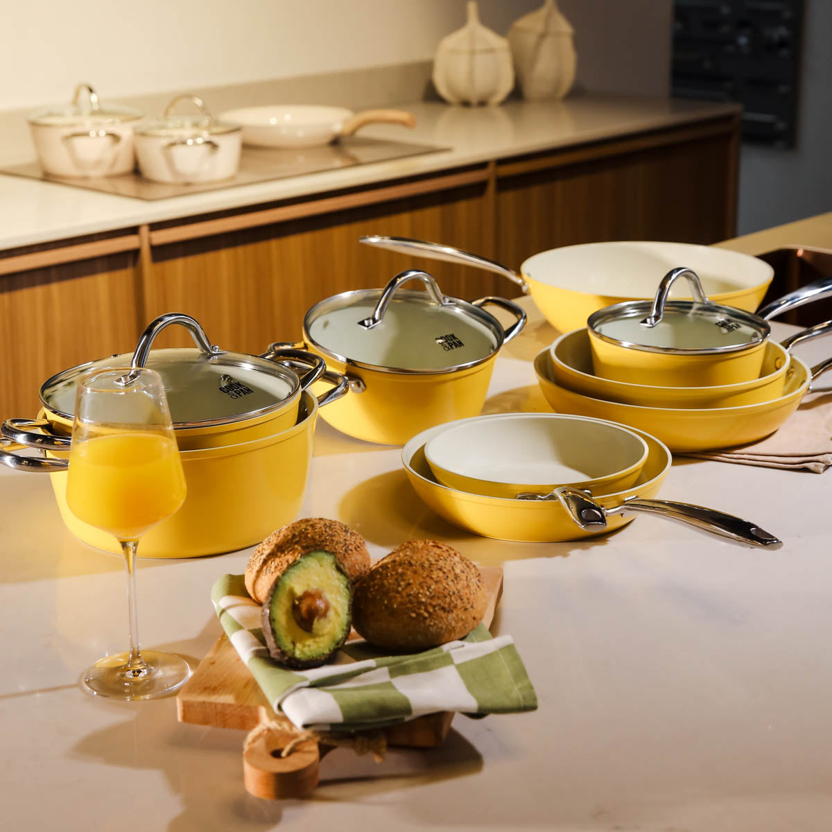 Complete yellow Sunny Side cookware set on kitchen counter with avocado