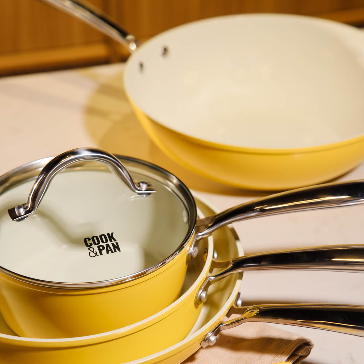 Yellow 9-piece cookware set with glass lid and stainless steel handles.
