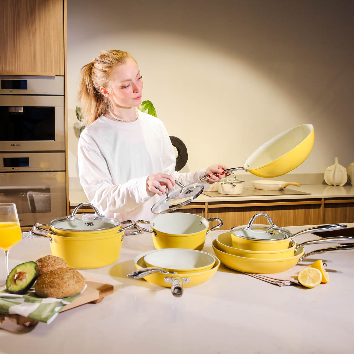 Yellow 9-piece cookware set with glass lids and non-stick coating, modern design.
