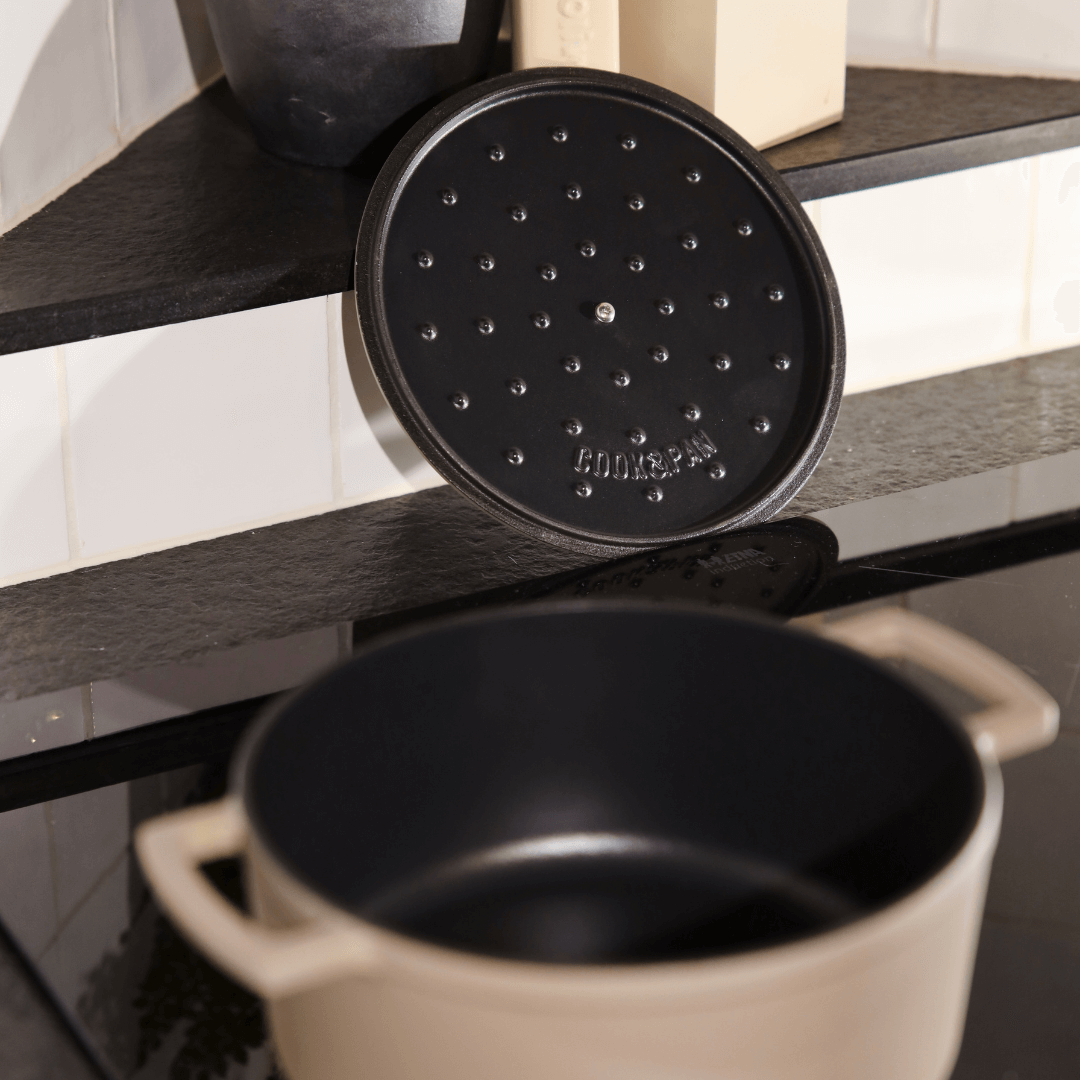 Cocotte en fonte taupe de 28 cm avec intérieur noir et couvercle à picots.