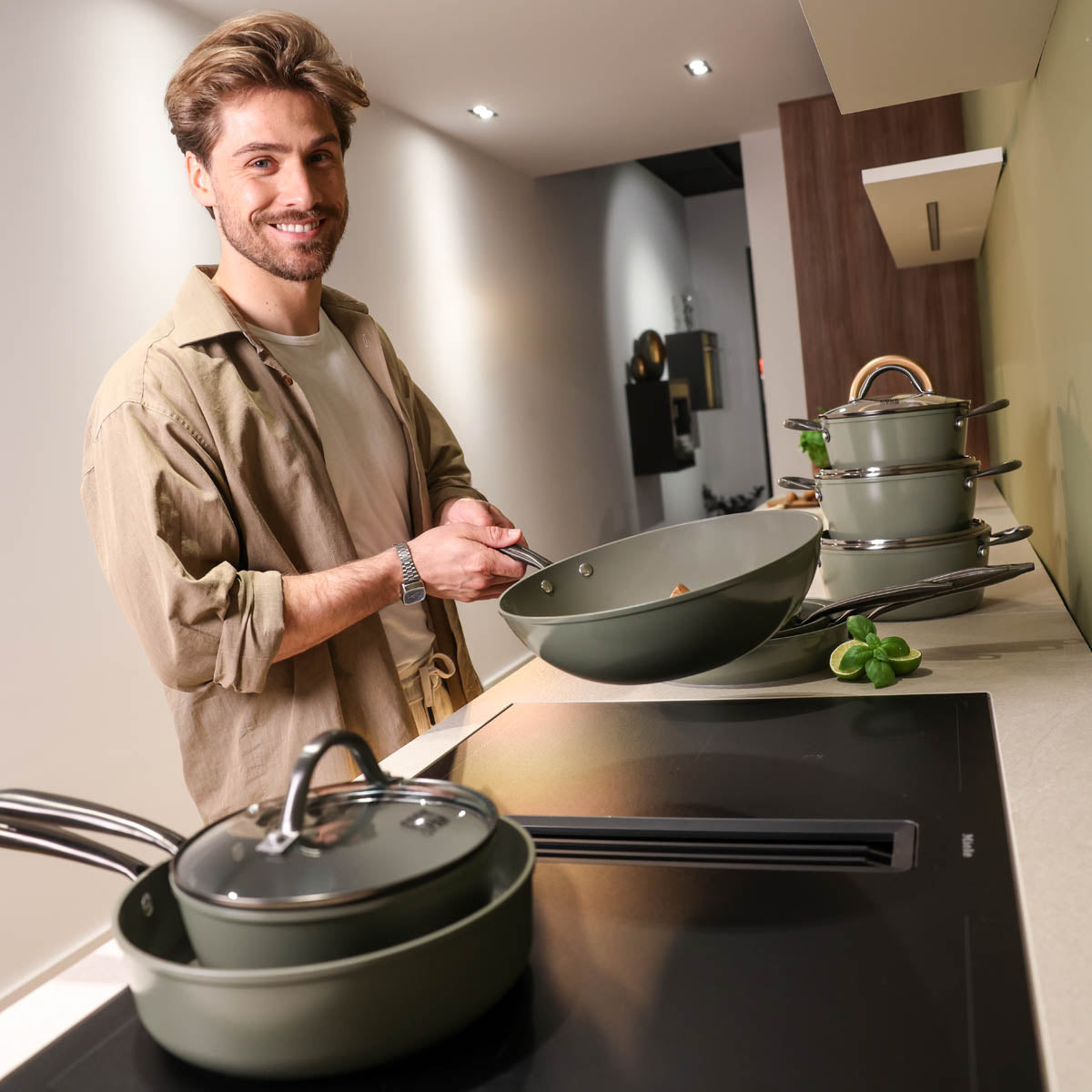 Donkergroene 9-delige pannenset met glazen deksel en roestvrijstalen handgrepen, modern design.