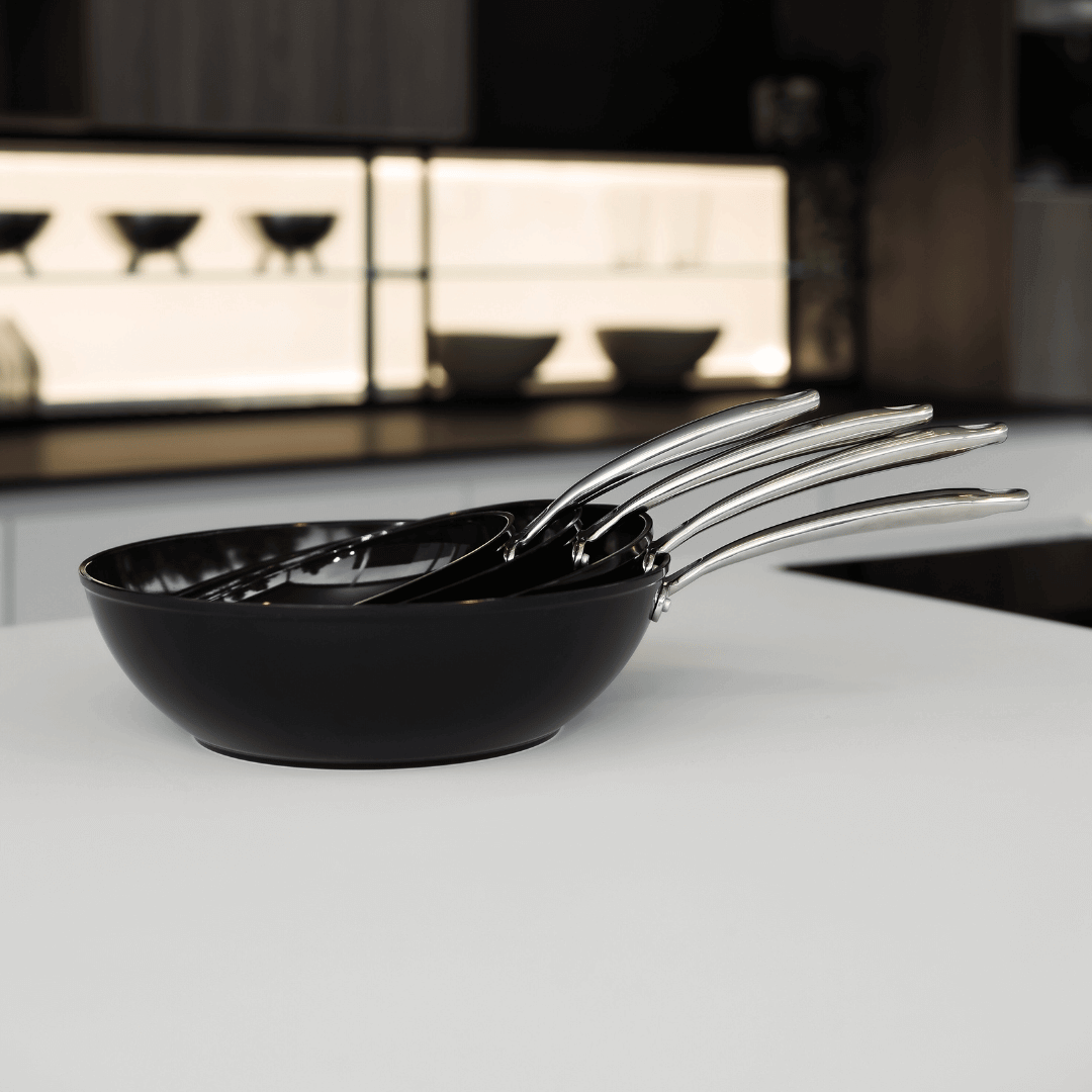 Casseroles et poêles noires empilées | Signature By C&P