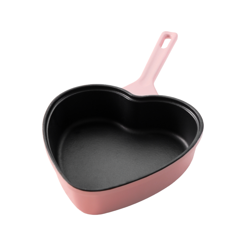 Pink cast iron frying pan in heart shape with black interior, 20 cm wide.