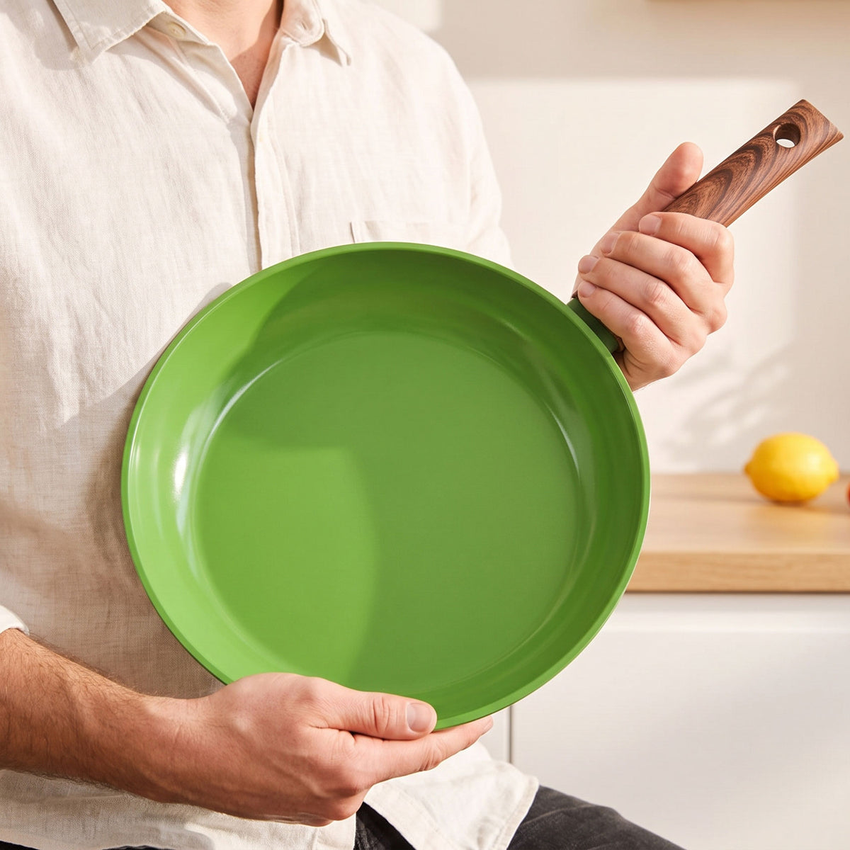 Green frying pan with wooden handle, sleek and durable design, ceramic non-stick coating.