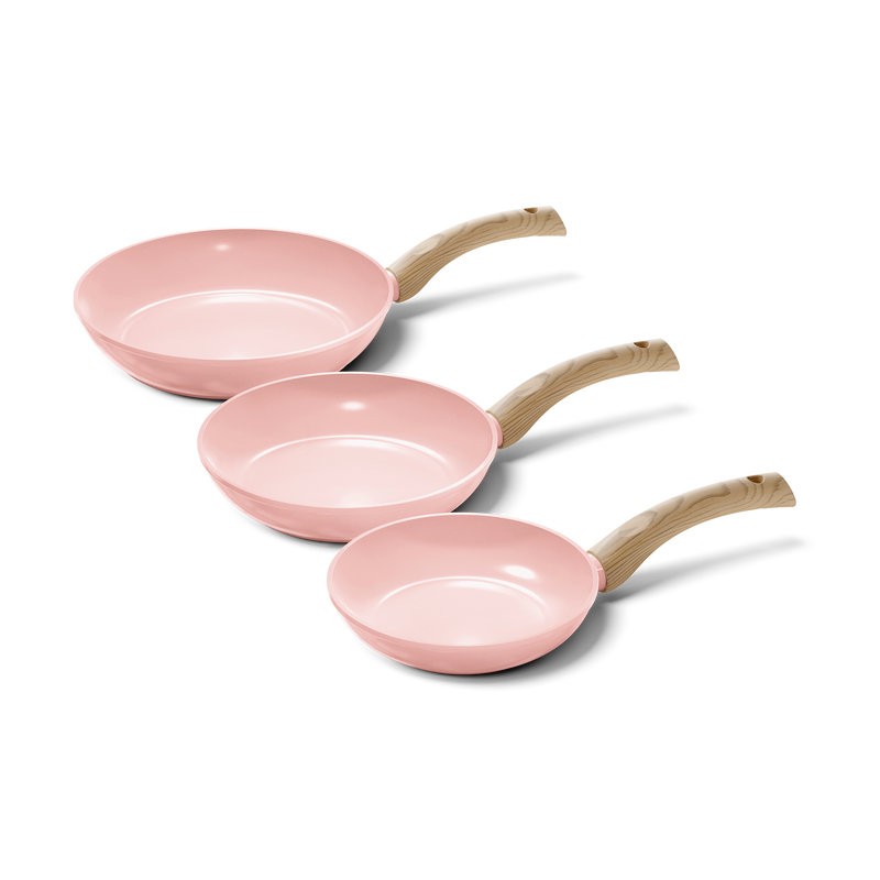 Three-piece Blush pink frying pan set with light wooden handles, varying in size.