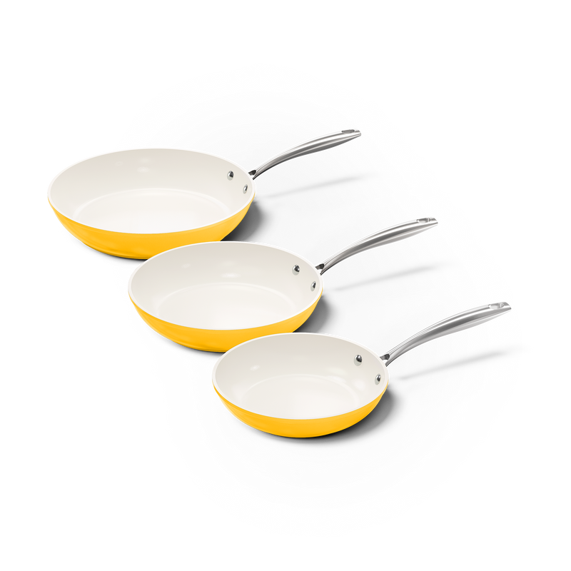 Set van drie gele koekenpannen met witte binnenkant en metalen handvatten in verschillende maten.