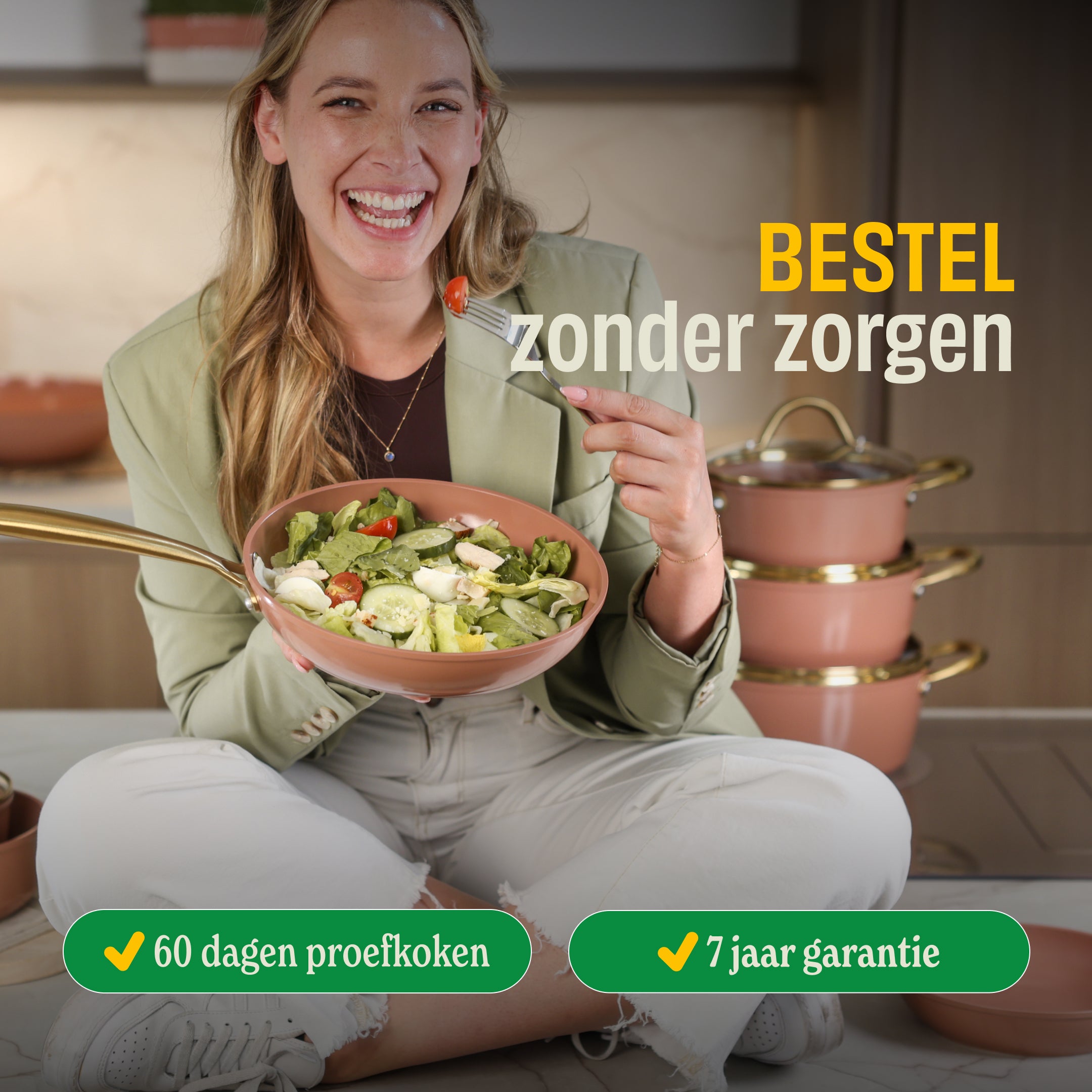 Vrouw met Go Ivory koekenpan gevuld met groenten en salade, achter haar gestapelde roze pannen