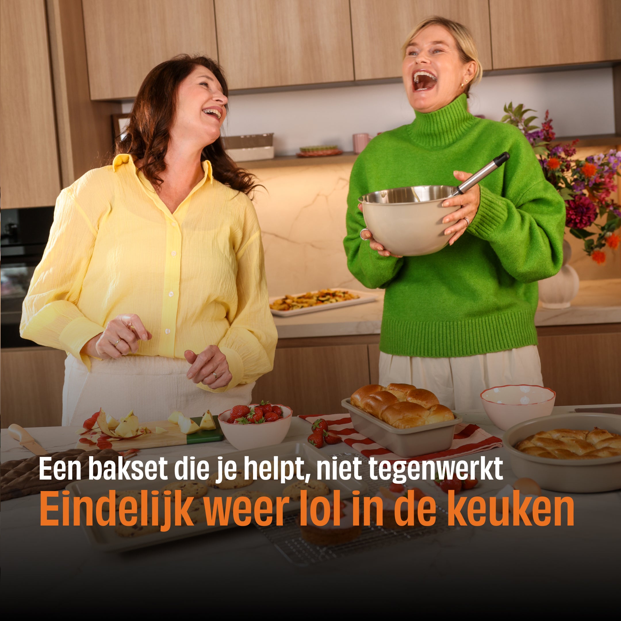 Zwei Frauen lachen in einer Küche mit einem Taupe of Mind Backset, eine hält eine Rührschüssel