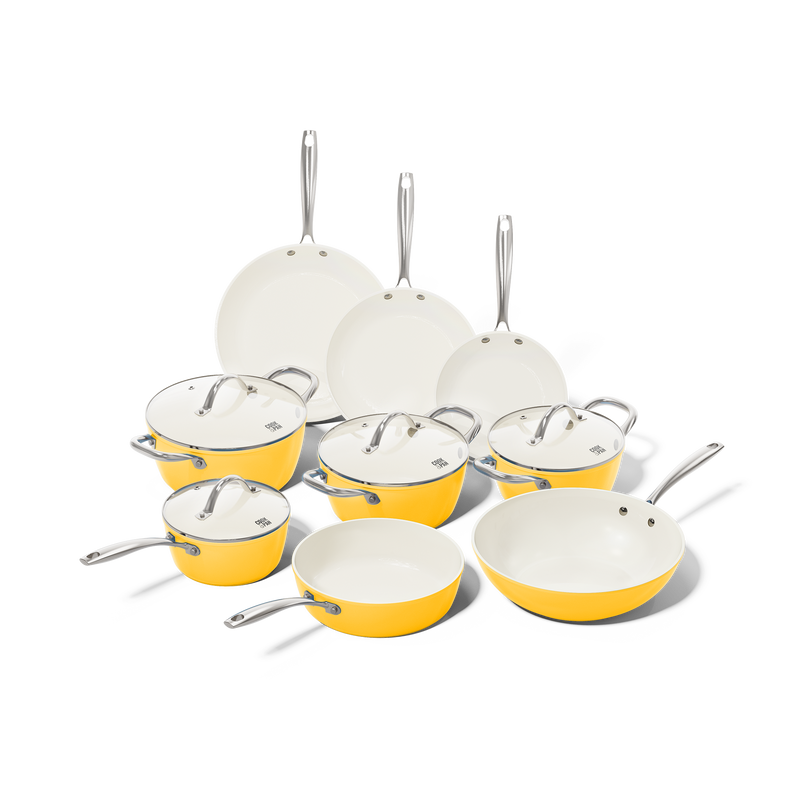 Yellow 9-piece cookware set with white interior and stainless steel handles including three frying pans and six lids.
