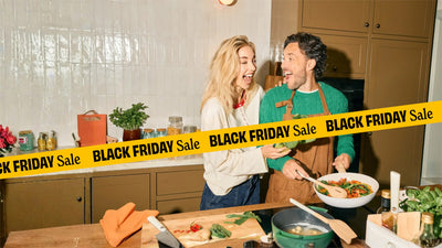 Lachend stel roerbakt samen groenten in een witte pan tijdens de Black Friday Sale