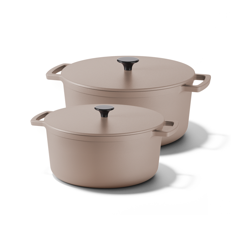 Two Taupe of Mind cast iron Dutch ovens in sand color with matching lids and side handles