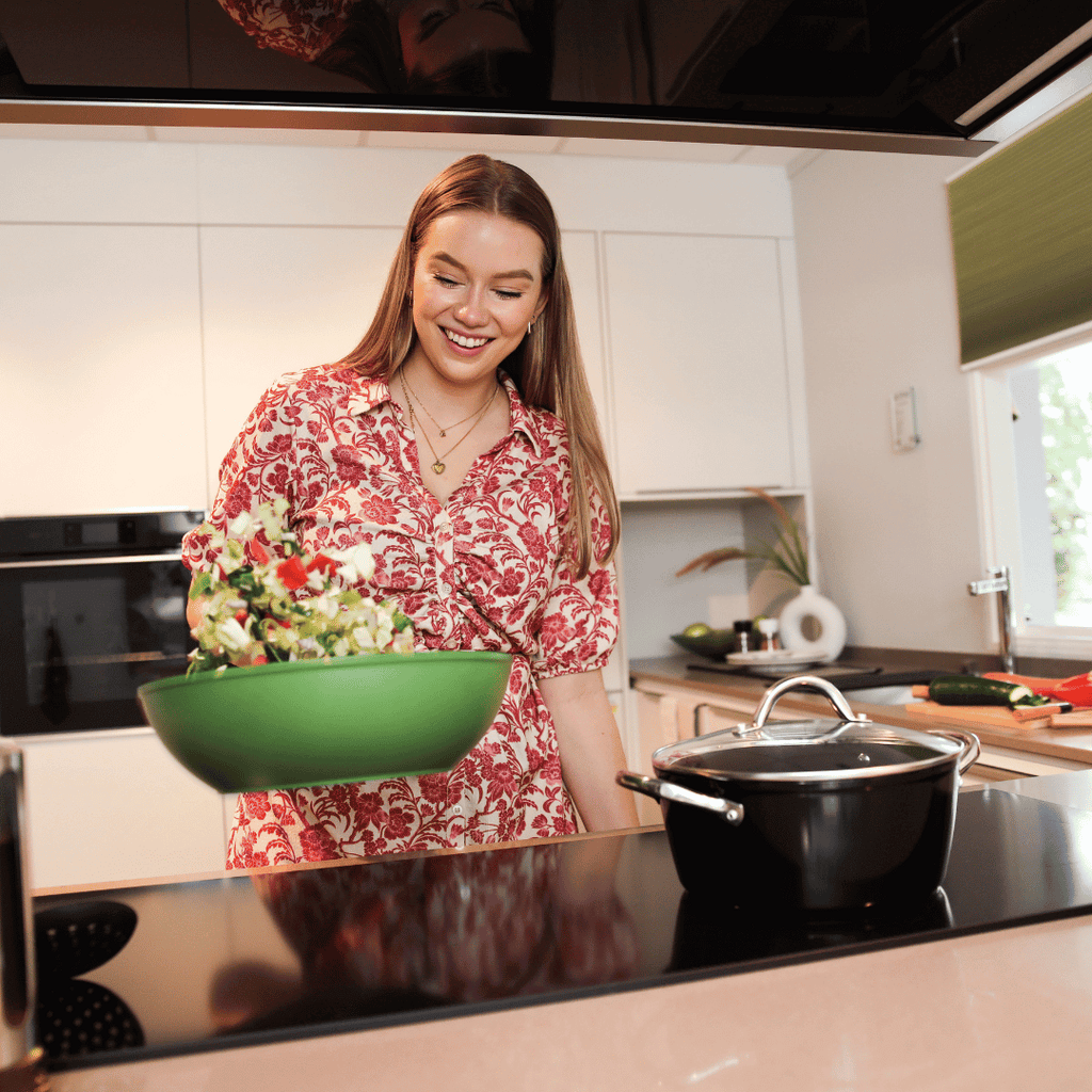 Vrouw kookt met een groene wokpan | Go green By C&P
