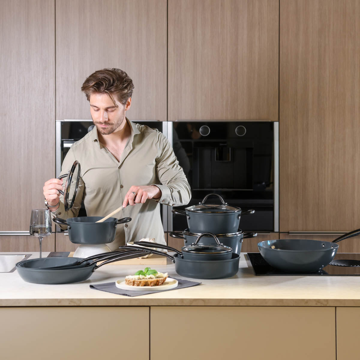 Black 9-piece cookware set with glass lids and heat-resistant handles, modern design.