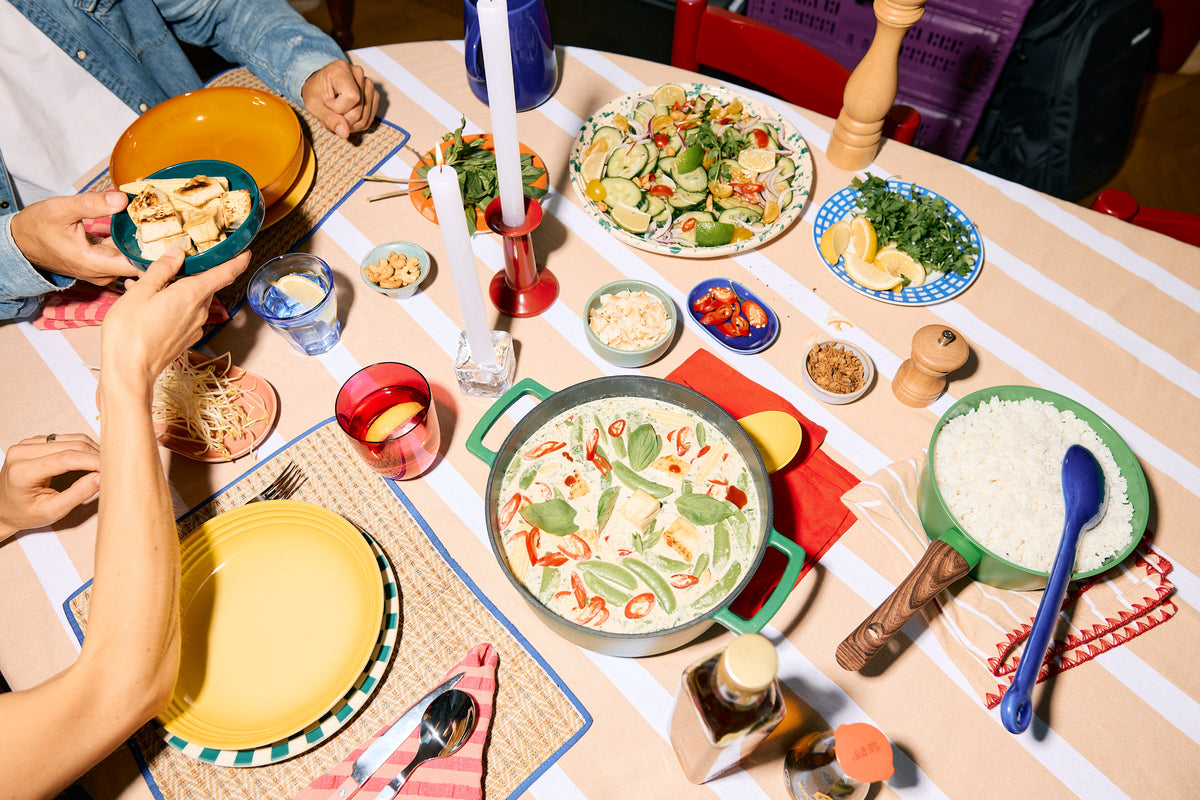 Gedekte tafel van bovenaf met een groene Cook & Pan braadpan vol eten