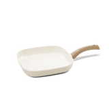 Square grill pan made of ivory-colored ceramic with a ribbed bottom and light wooden handle, 28 cm.