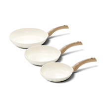 Set de trois poêles antiadhésives avec intérieur blanc et poignées en bois clair.