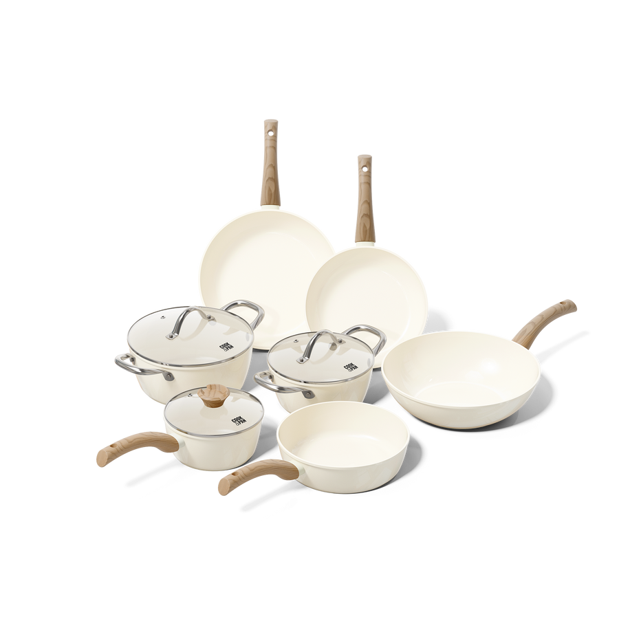 Batterie de cuisine ivoire 7 pièces avec poignées en bois et couvercles en verre.