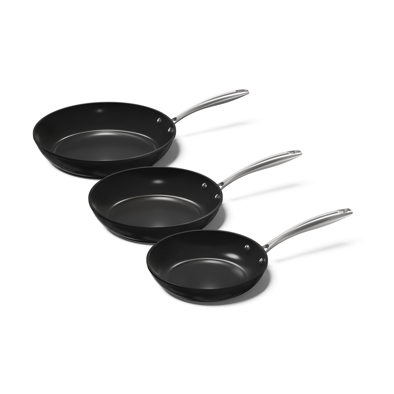 Set aus drei schwarzen Pfannen mit silbernen Griffen in verschiedenen Größen.