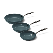 Set aus drei anthrazitgrauen Pfannen mit schwarzen Griffen und Metallbefestigungen.