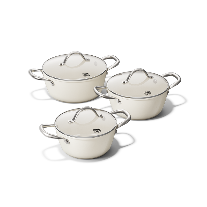 Three-piece ivory-colored pots and pans set with stainless steel handles and lids.