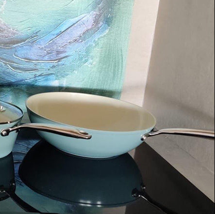 Set of blue wok pan 30 cm with lid, medium pan with lid and light blue casserole pot with long handle.