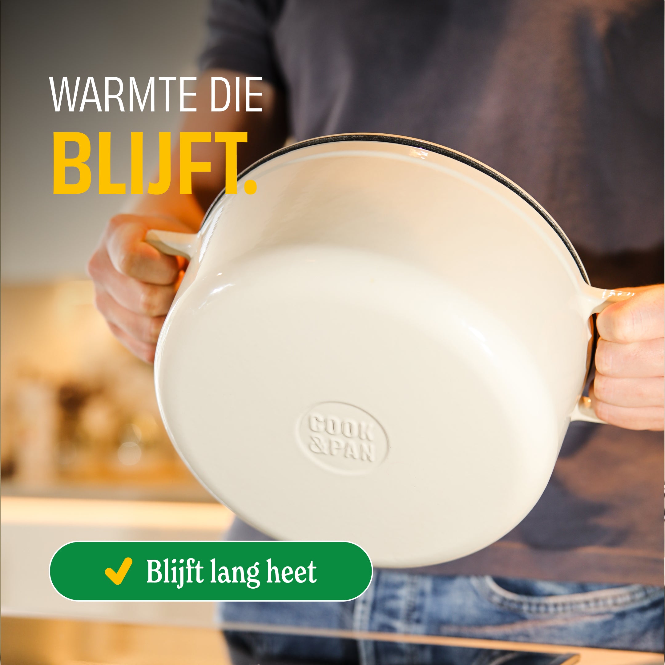 Handen houden een crème Go Ivory gietijzeren braadpan schuin, blijft lang heet