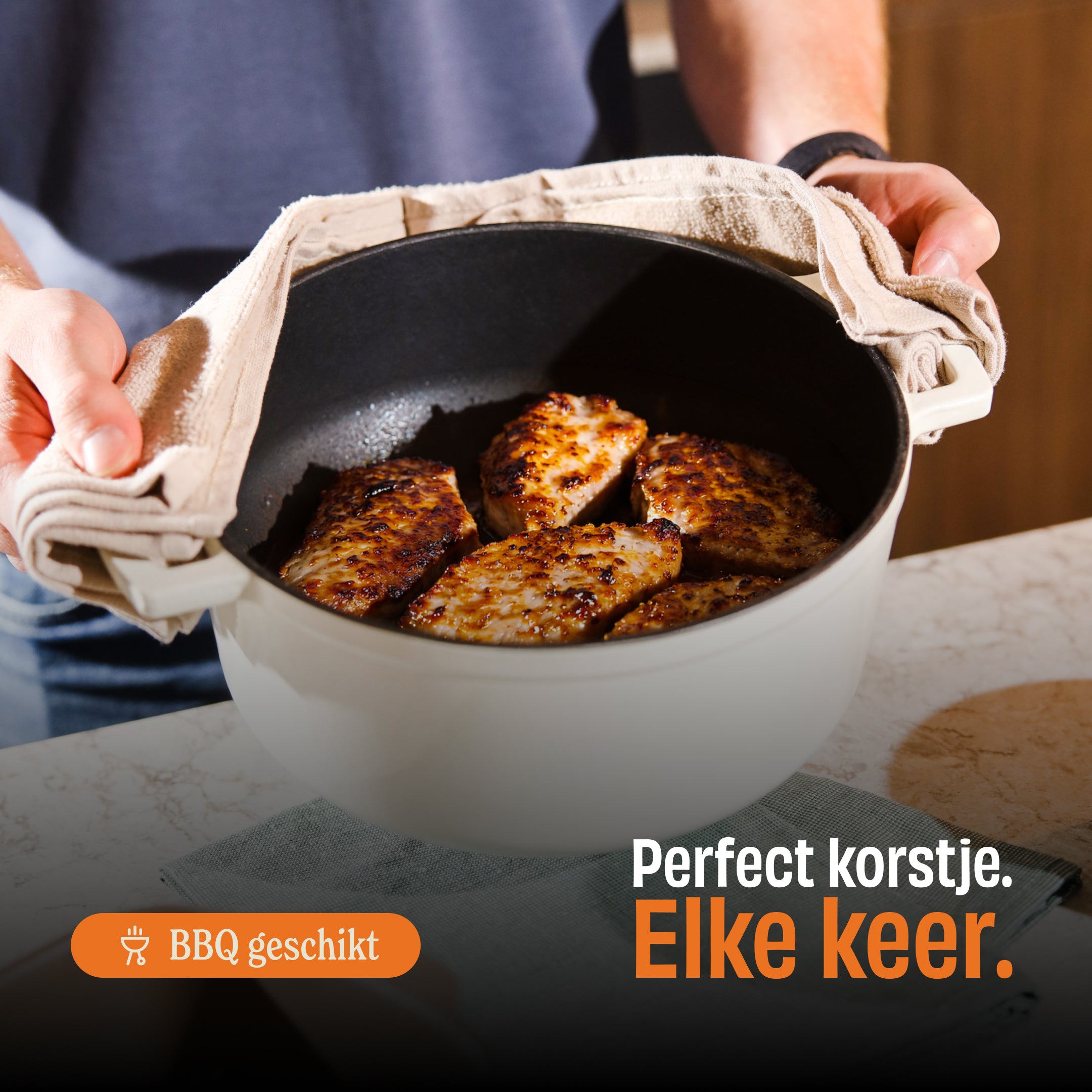 Handen houden een ivoren gietijzeren braadpan met goudbruin geroosterde kippeschenkels en BBQ-geschikt label