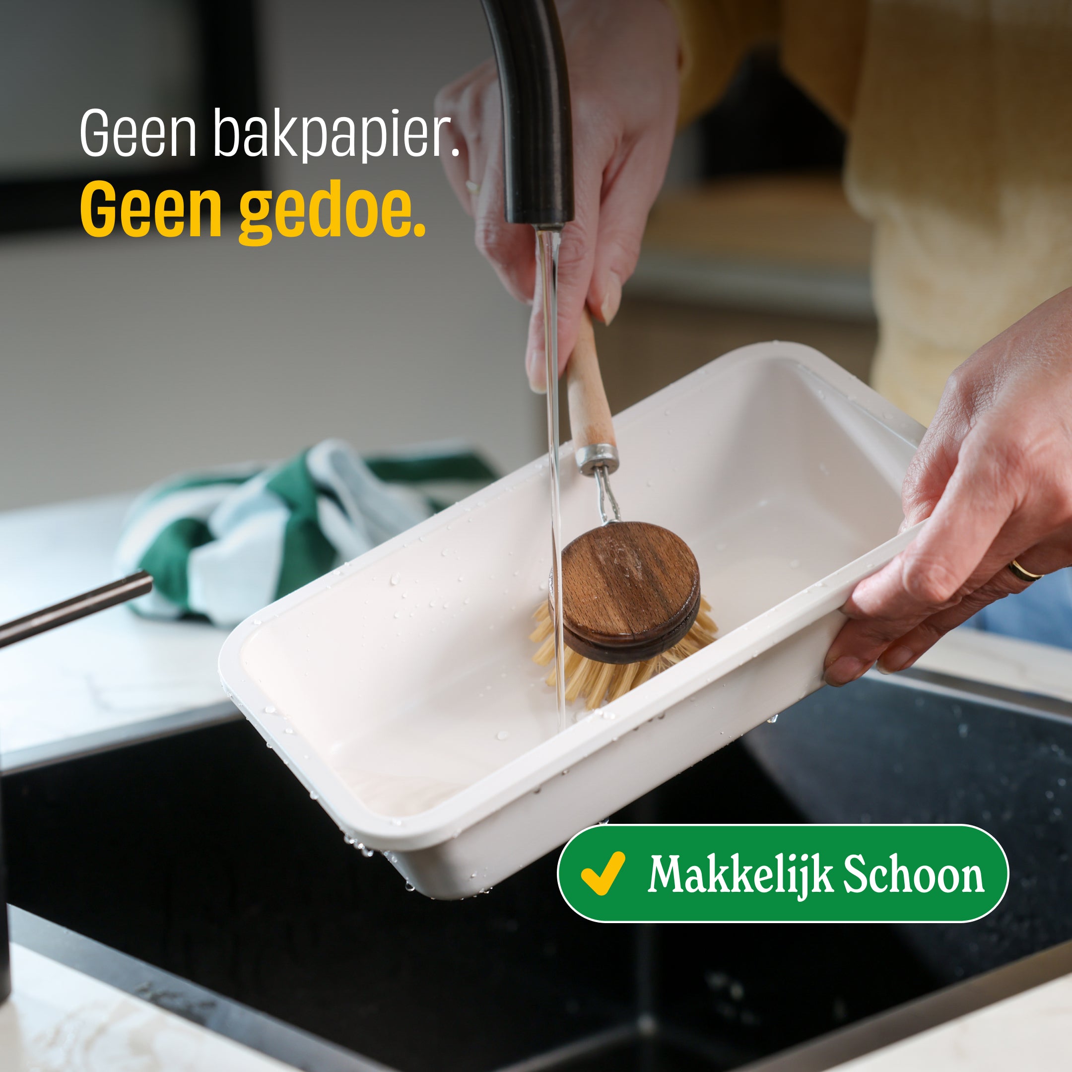 Bakset van Go Ivory zonder bakpapier nodig, voorkant van witte bak met houten borstel in water wordt gebruikt