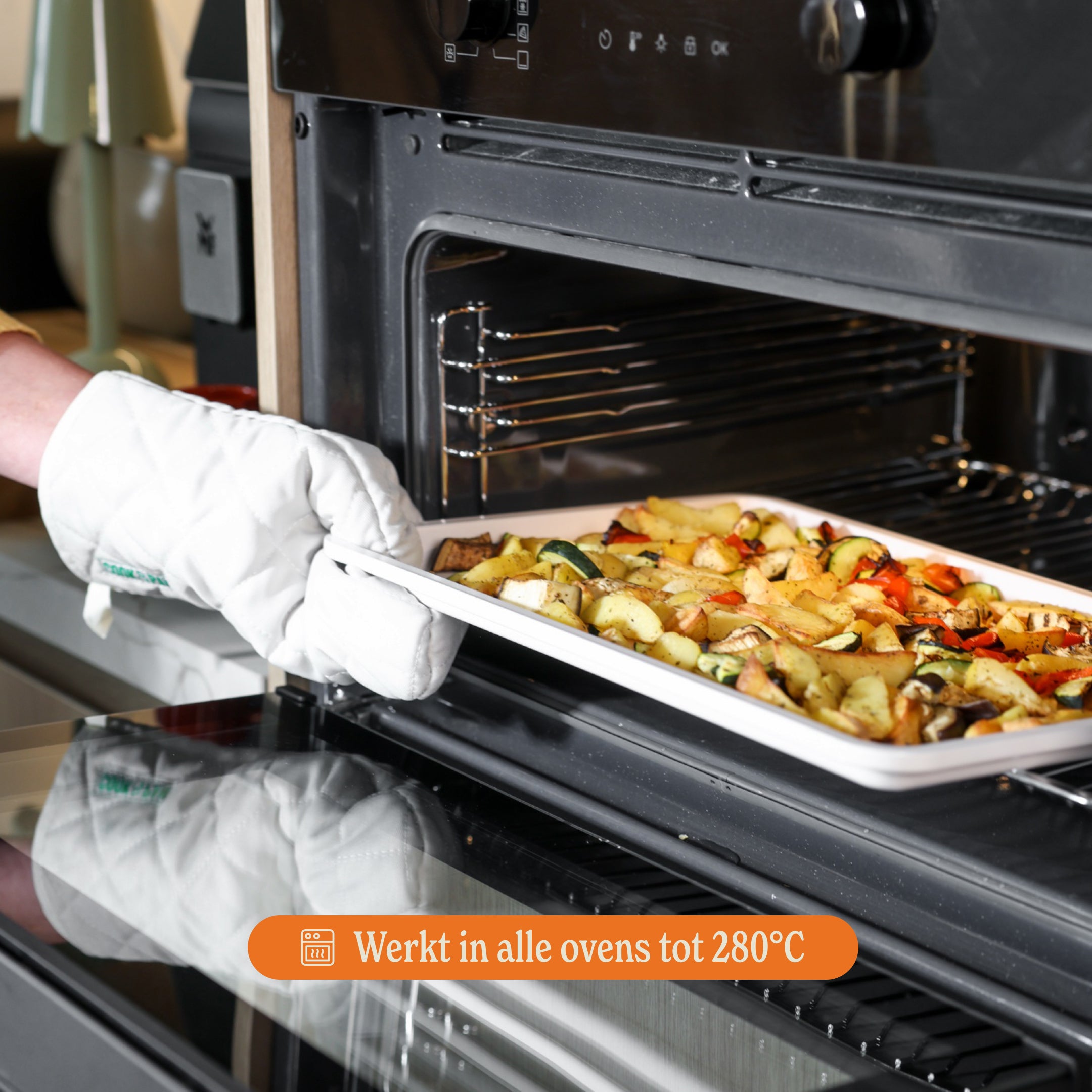 Go Ivory bakset met witte ovenhandschoenen haalt een schaal met groenten uit de oven, werkt tot 280°C