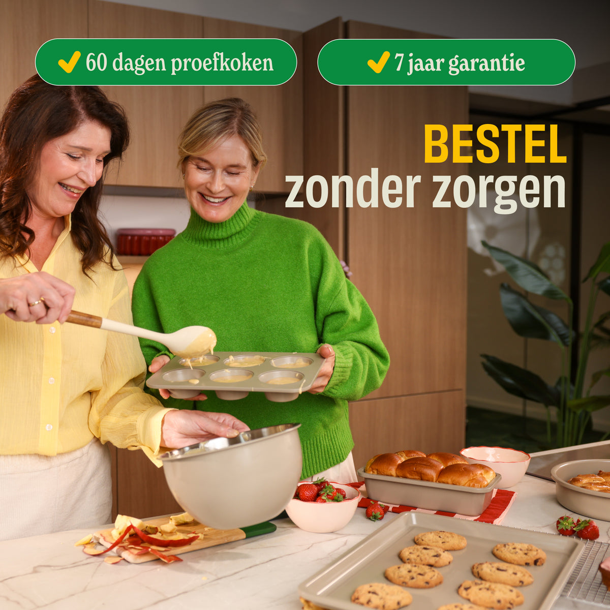 Zwei Frauen kochen zusammen mit cremefarbenem Go Ivory Backset, umgeben von Backwaren und Obst in einer modernen Küche
