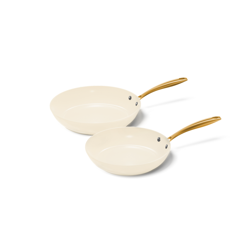 Vanilla koekenpannenset met twee crèmekleurige koekenpannen met keramische antiaanbaklaag en gouden handvatten.